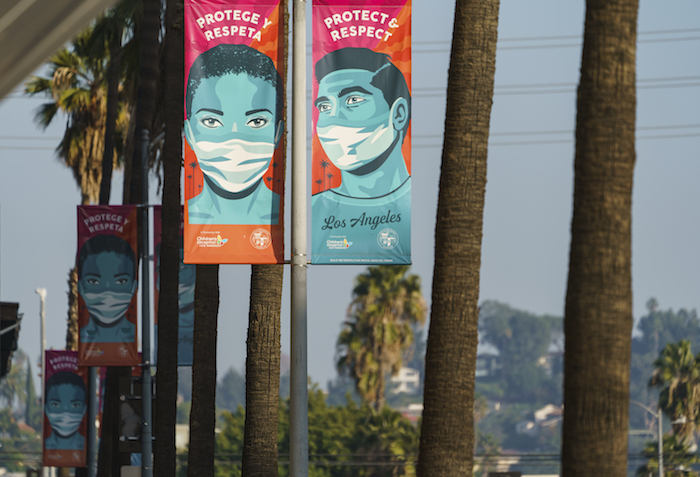 Anuncios que aconsejan a las personas protegerse contra el coronavirus, colocados en el Hollywood Boulevard de Los Ángeles, California, el 5 de enero de 2021. 