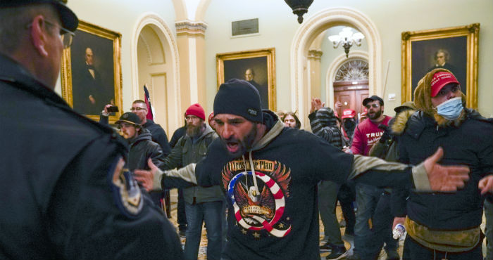 Simpatizantes del Presidente Donald Trump se enfrentan a la policía del Capitolio en el vestíbulo del recinto del Senado, el miércoles 6 de enero de 2021, en Washington.