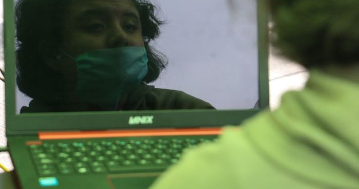 Una mujer frente a una laptop.