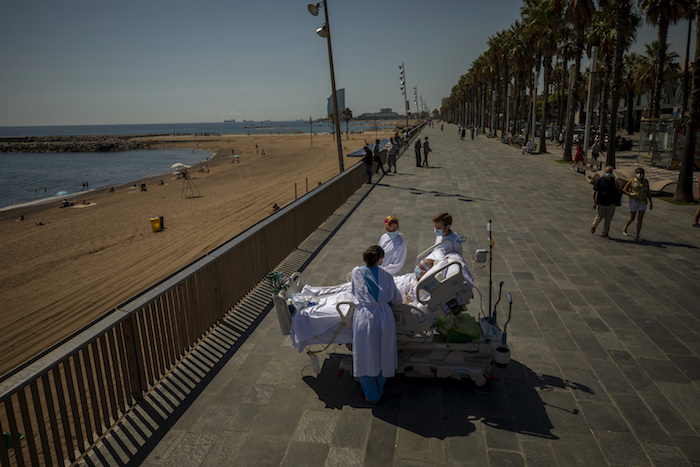 En esta imagen de archivo, tomada el 4 de septiembre de 2020, Francisco España, de 60 años, rodeado por miembros del equipo médico que lo atiende, mira al mar Mediterráneo desde su cama en el paseo próximo al Hospital del Mar, en Barcelona. España pasó 52 días en la Unidad de Cuidados Intensivos del centro a causa del coronavirus, pero ese día sus doctores le permitieron pasar casi 10 minutos al borde del mar como parte de su terapia de recuperación. 