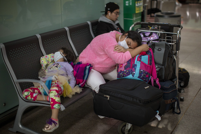 En esta imagen de archivo, tomada el 12 de marzo de 2020, pasajeros duermen en el aeropuerto de Barcelona, España. El entonces Presidente de Estados Unidos, Donald Trump, quien durante semanas había restado importancia al brote, anunció estrictas restricciones para viajar desde gran parte de Europa. 