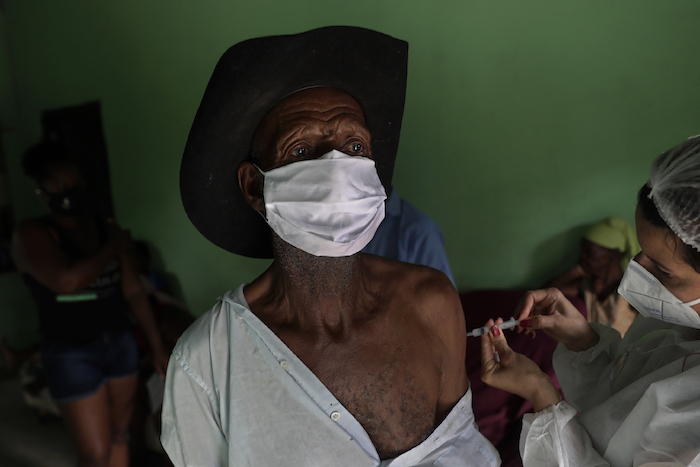 Con mascarilla para protegerse del coronavirus, Algemiro Dias, de 82 años, recibe la primera inyección de la vacuna de Sinovac contra la COVID-19, en la comunidad Kalunga Vao de Almas, una zona rural a las afueras de Cavalcante, en el estado de Goias, Brasil, el 15 de marzo de 2021. 