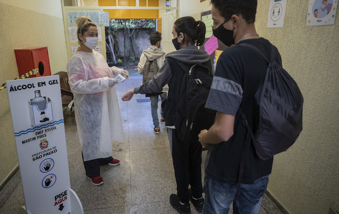 Marilene de Oliveira Paixao toma la temperatura de estudiantes que ingresan a la escuela EMEF Sylvia Martin Pires en Sao Paulo, Brasil, el lunes 8 de marzo de 2021. 