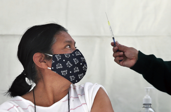 Una mujer se prepara para recibir una inyección de la vacuna de AstraZeneca contra la COVID-19 en la Ciudad de México, el lunes 15 de febrero de 2021. 