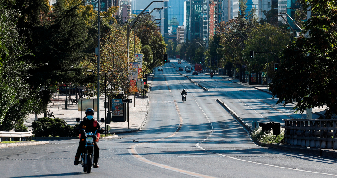 Un motociclista transita el 27 de marzo de 2021 por una avenida casi vacía durante la cuarentena obligatoria decretada en prácticamente todo el país ante el avance de la pandemia de COVID-19, en Santiago (Chile).