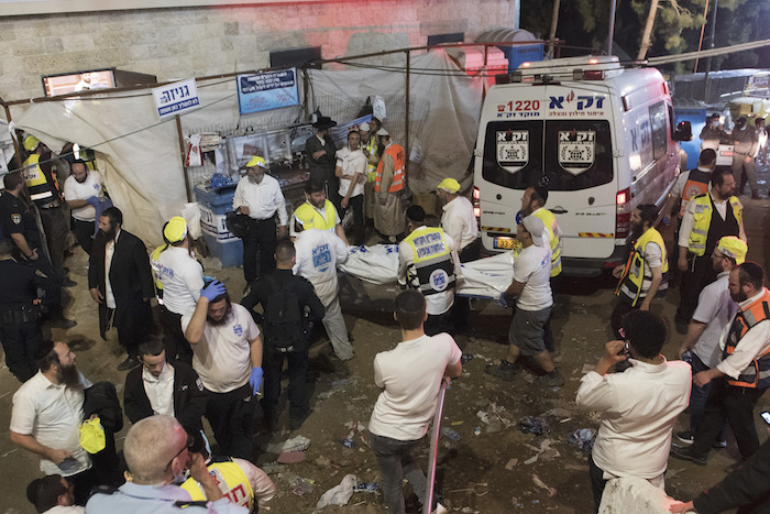 Agentes de seguridad y rescatistas israelíes cargan el cuerpo de una víctima que falleció durante las celebraciones del Lag Ba'Omer, el viernes 30 de abril de 2021 en el norte de Israel.