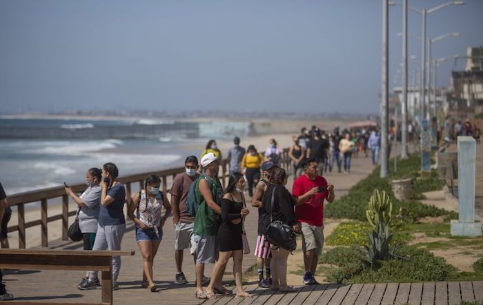 Ciudadanos pasean por el malecón de Tijuana a pesar de que la playa estaba cerrada durante la Semana Santa. 