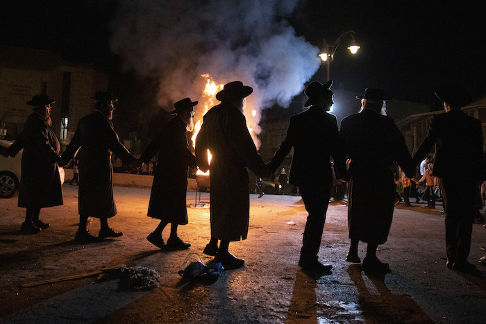 Un grupo de judíos ultraortodoxos bailan el jueves 29 de abril de 2021 junto a una fogata en Jerusalén. 