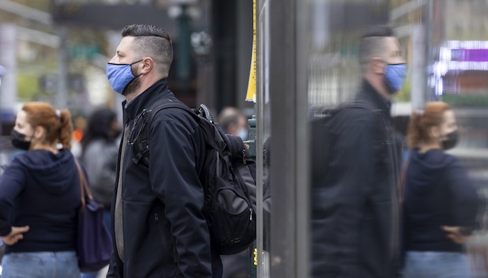 Un hombre con mascarilla esperan en una calle de Nueva York (EU), hoy 27 de abril de 2021. 