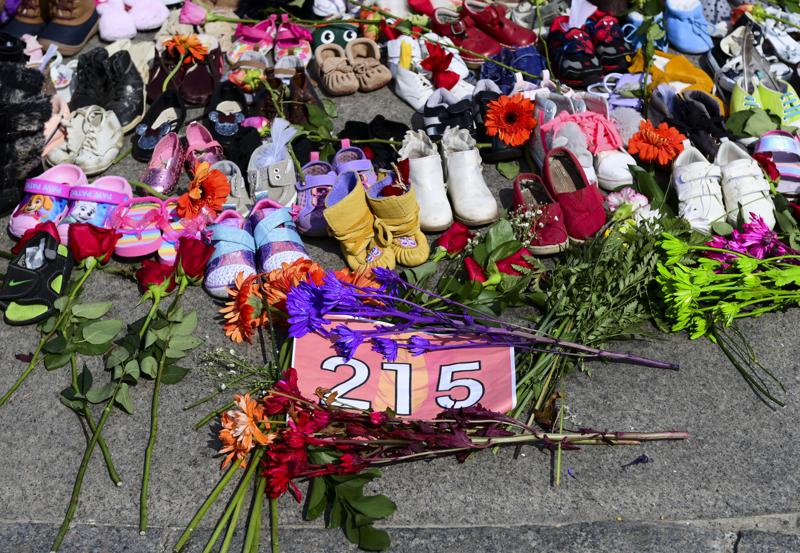 Flores, zapatos para niños y otros artículos descansan en un monumento en la Llama Eterna en Parliament Hill en Ottawa.