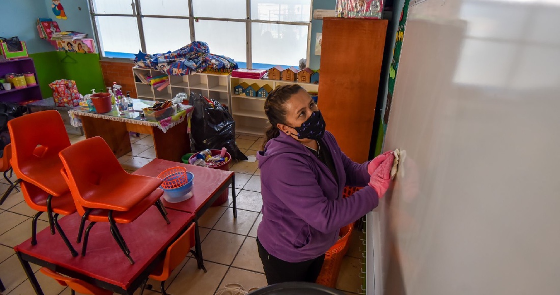 Una mujer limpia una escuela en Toluca