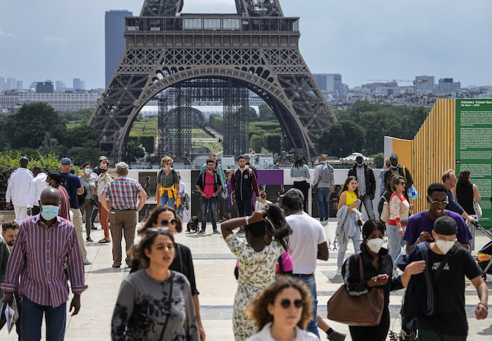 Unas personas caminan en la Plaza Trocadero cerca de la Torre Eiffel en París, el lunes 26 de julio de 2021. 