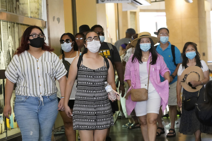 En esta imagen del 1 de julio de 2021, visitantes portan mascarillas al caminar por una zona comercial en el sector de Hollywood, en Los Ángeles.