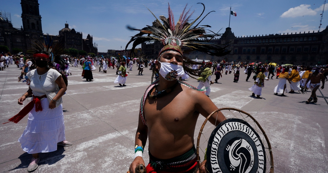 Bailarines participan en una ceremonia para conmemorar el 700 aniversario de la fundación de la ciudad azteca de Tenochtitlan, hoy conocida como Ciudad de México, en la Plaza del Zócalo, en la Ciudad de México, el 26 de julio de 2021, en plena pandemia del coronavirus.