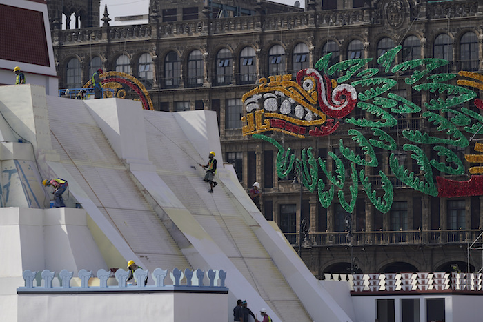 Operarios construyen una réplica del Templo Mayor azteca, con una imagen del dios precolombino Quetzalcoatl adornando los edificios colindantes, en la Plaza del Zócalo, en Ciudad de México, el 9 de agosto de 2021.