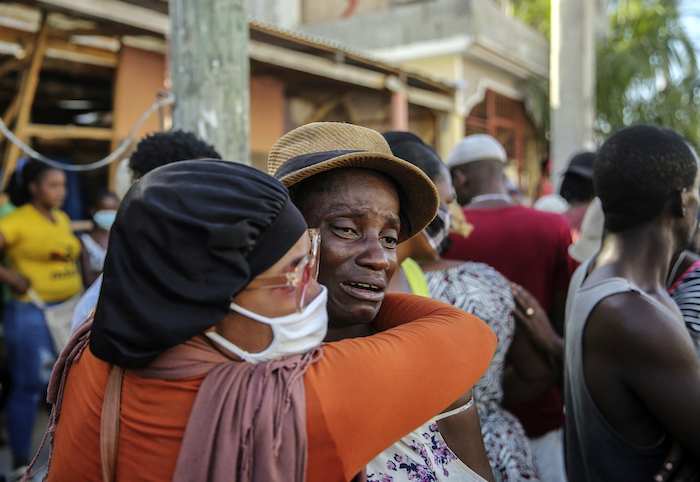 Dos personas se abrazan llorando el 15 de agosto del 2021 en Les Cayes, Haití, mientras buscan desaparecidos entre los escombros de una casa destruida por un terremoto que golpeó el día previo.