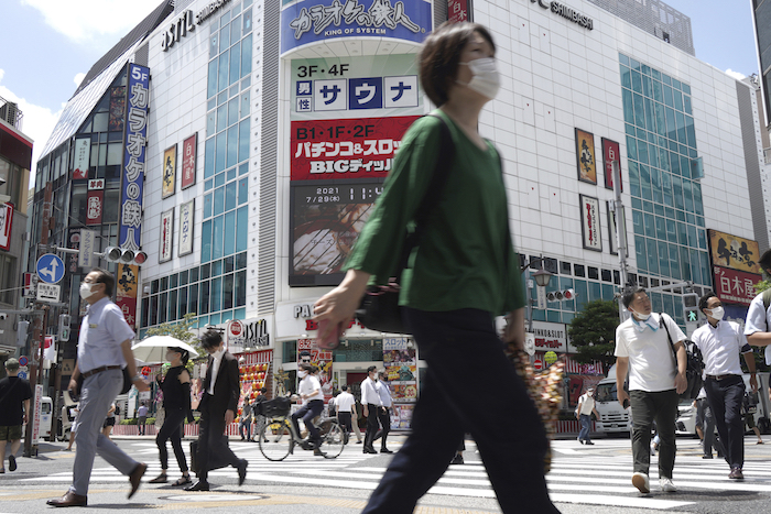 Gente caminando por un cruce cerca de la estación de tren de Shimbashi en Tokio, el jueves 29 de julio de 2021, al día siguiente de que se batiera un récord de contagios del virus en la ciudad anfitriona de los Juegos Olímpicos.