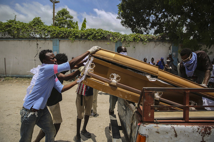 Varios individuos cargan en una camioneta el féretro con el cadáver Francois Elmay para ser enterrado en un cementerio de Les Cayes, Haití, el 18 de agosto del 2021. Elmay falleció en el terremoto que sacudió Haití el sábado 14 de agosto.