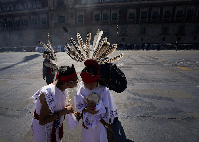 Dos jóvenes charlan antes de participar en la conmemoración del 700 aniversario de la fundación de la ciudad azteca de Tenochtitlan, hoy conocida como Ciudad de México, en la Plaza del Zócalo, en la Ciudad de México, el 26 de julio de 2021, en plena pandemia del coronavirus.