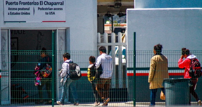 Migrantes centroamericanos cruzan hacia Estados Unidos por la línea ubicada en la ciudad del El Chaparral, en la fronteriza Tijuana (México).