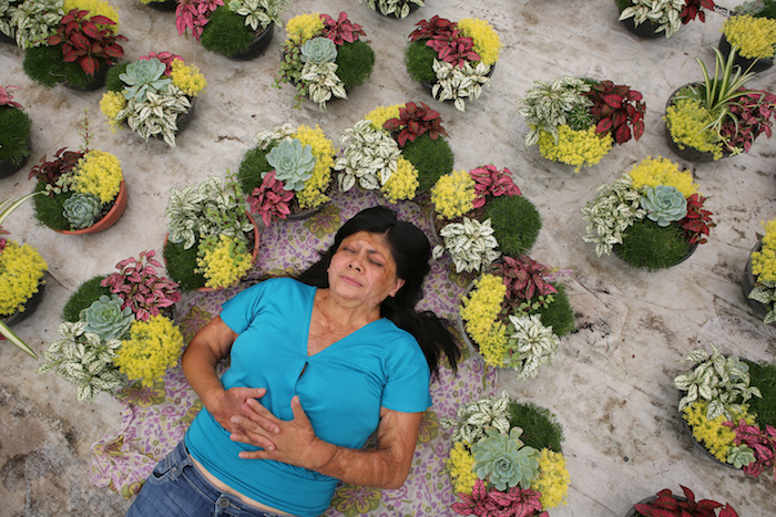 Elisa Xolalpa, quien sobrevivió a un ataque con ácido por su expareja hace 20 años cuando ella tenía 18 años, posa para un retrato dentro de su invernadero en Ciudad de México, el domingo 30 de mayo de 2021.