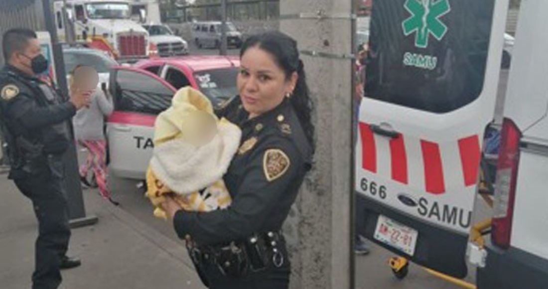 Policía carga a bebé que nació en un taxi de la Ciudad de México.