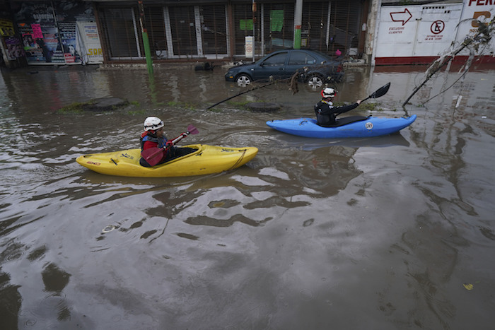 Una pareja navega sus kayaks por una calle inundada en Tula, en el estado de Hidalgo, México, el martes 7 de septiembre de 2021.