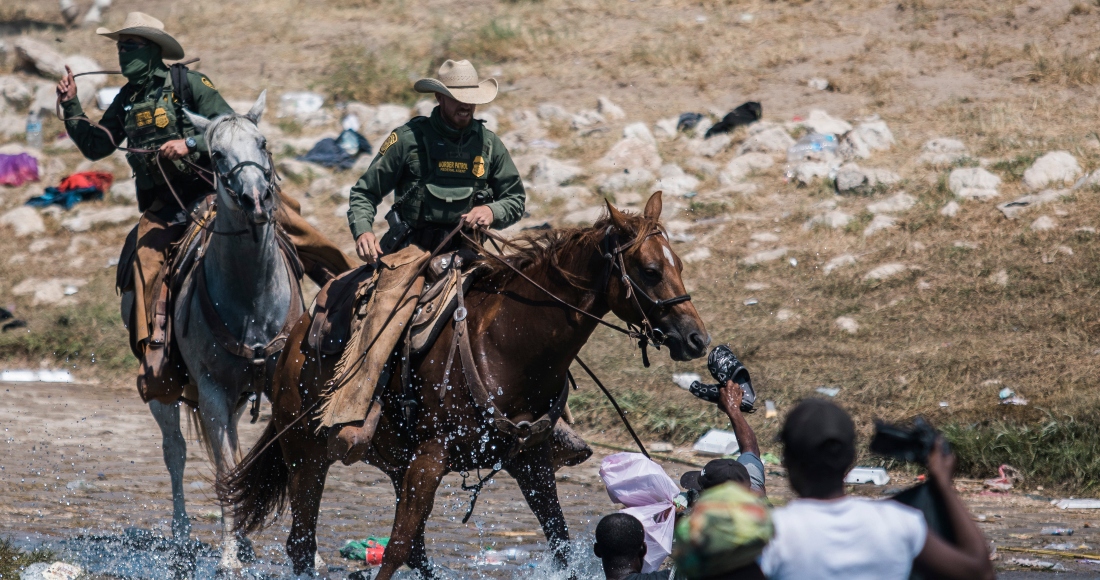 Guardias fronterizos a caballo tratan de impedir el paso de migrantes que cruzan el río Bravo desde Ciudad Acuña, México, a Del Río, Texas, 19 de setiembre de 2021.