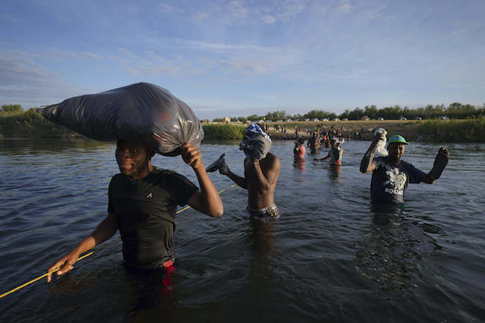 Migrantes, muchos de Haití, cruzan el Río Bravo mientras abandonan Del Río, Texas, para regresar a Ciudad Acuña, México, el miércoles 22 de septiembre de 2021 temprano, algunos para evitar una posible deportación de EU otros a conseguir suministros.