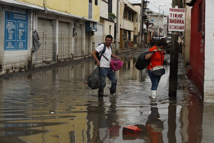 Personas rescatan sus pertenencias luego de una inundación producida por fuertes lluvias, el 9 de septiembre de 2021, en el municipio de Tula, en Hidalgo (México).