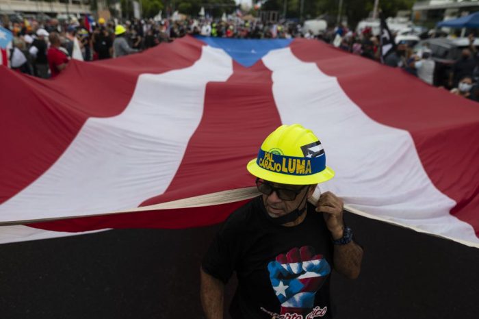 La gente marcha a lo largo de la carretera Las Américas para protestar contra la compañía Luma Energy en San Juan, Puerto Rico, el viernes 15 de octubre de 2021.