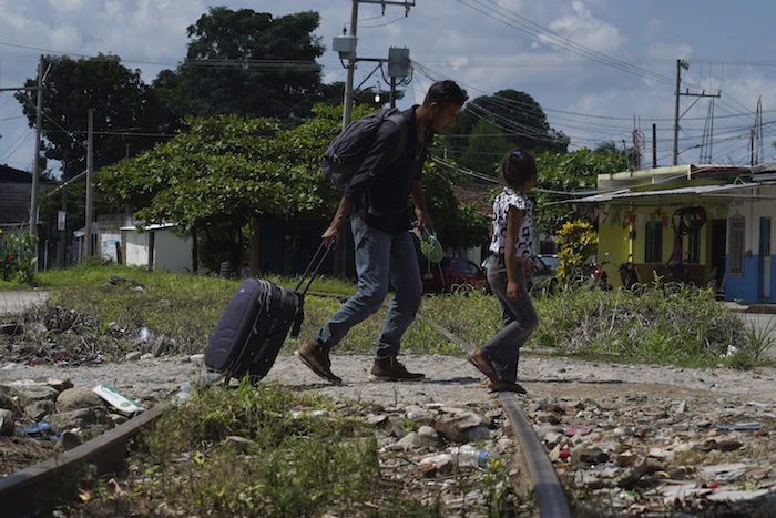 Los migrantes que forman parte de una caravana cruzan una vía de tren en Huixtla, estado de Chiapas, México, el martes 26 de octubre de 2021, en un día de descanso antes de continuar su viaje por el sur de México hasta la frontera con Estados Unidos.