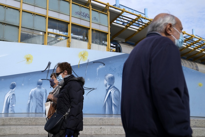 Peatones con mascarillas para protegerse del coronavirus pasan ante una estación de metro en Atenas, Grecia, el lunes 15 de noviembre de 2021.