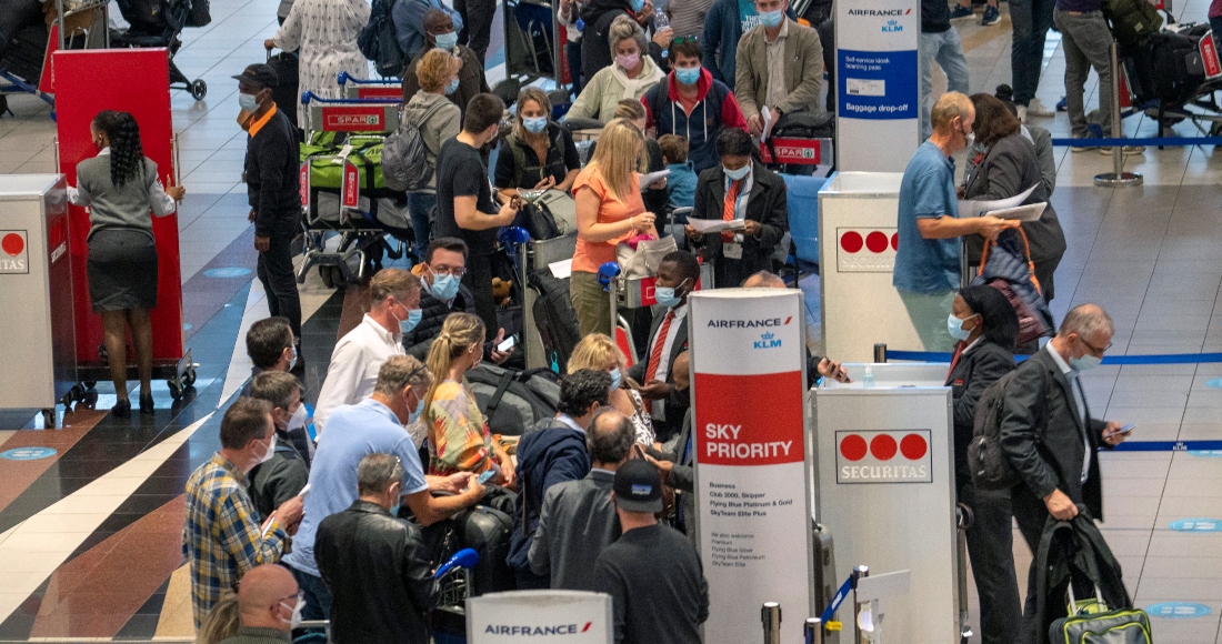 Decenas de personas hacen fila para tomar un vuelo de Air France a París en el aeropuerto internacional Tambo en Johannesburgo, Sudáfrica, el viernes 26 de noviembre de 2021.