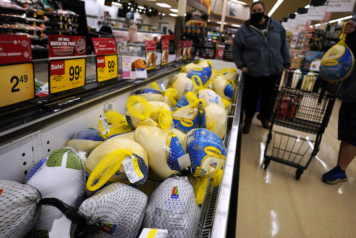 Dos personas junto a una nevera con pavos congelados para la cena de Acción de Gracias en una tienda en Mount Prospect, Illinois, el miércoles 17 de noviembre de 2021.