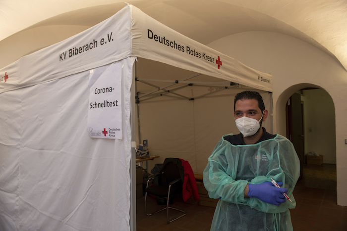 Un trabajador de Cruz Roja, Motasen Edrees, de pie ante una tienda de campaña donde realiza pruebas rápidas de COVID-19, en el ayuntamiento de Biberach, Alemania, el 10 de noviembre de 2021.