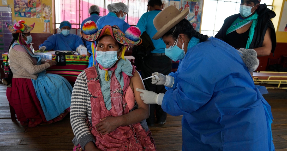 Una trabajadora de la salud le da una inyección de la vacuna Sinopharm contra la COVID-19 a Yolanda Coila, durante una campaña de vacunación en Jochi San Francisco, Perú, el viernes 29 de octubre de 2021.