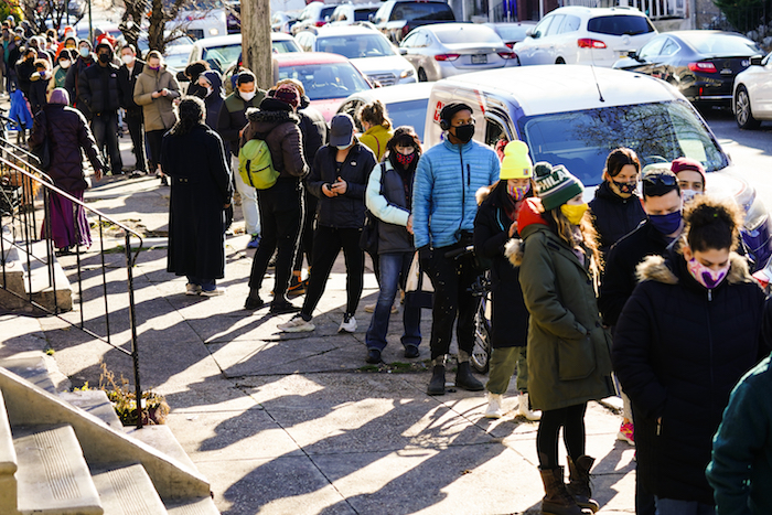 Los residentes de Filadelfia esperan en una fila, el lunes 20 de diciembre de 2021, para recibir kits gratuitos de pruebas rápidas de COVID-19.