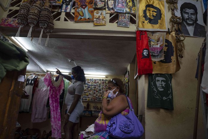 Una mujer espera que le muestren un vestido en una tienda privada de ropa y artesanías en La Habana, Cuba, el 16 de septiembre de 2021.