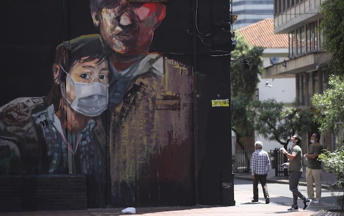 Un mural muestra a un joven con una mascarilla para protegerse del coronavirus, el lunes 13 de abril de 2021, en Bogotá, Colombia.