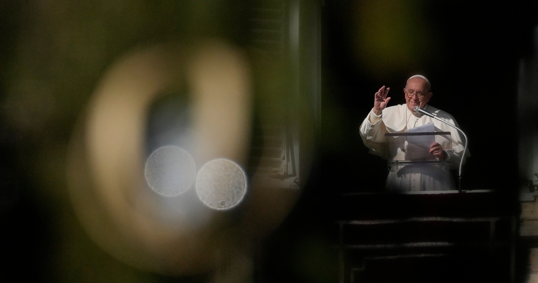 El Papa Francisco, detrás del árbol de Navidad del Vaticano, saluda a los fieles desde la ventana de su estudio con vista a la Plaza de San Pedro, en el Vaticano, el domingo 12 de diciembre de 2021.