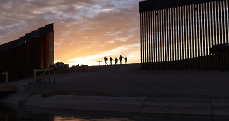 Un par de familias migrantes de Brasil que buscan asilo caminan por una brecha en el muro fronterizo para llegar a Estados Unidos después de cruzar de México a Yuma, Arizona, el 10 de junio de 2021.