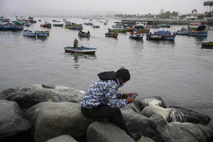 Un pescador descansa cerca del muelle en Ancón, Perú, el jueves 20 de enero de 2022. El derrame de petróleo en la costa peruana provino por el oleaje que se produjo tras la erupción de un volcán submarino en Tonga, una nación en el Pacífico Sur.