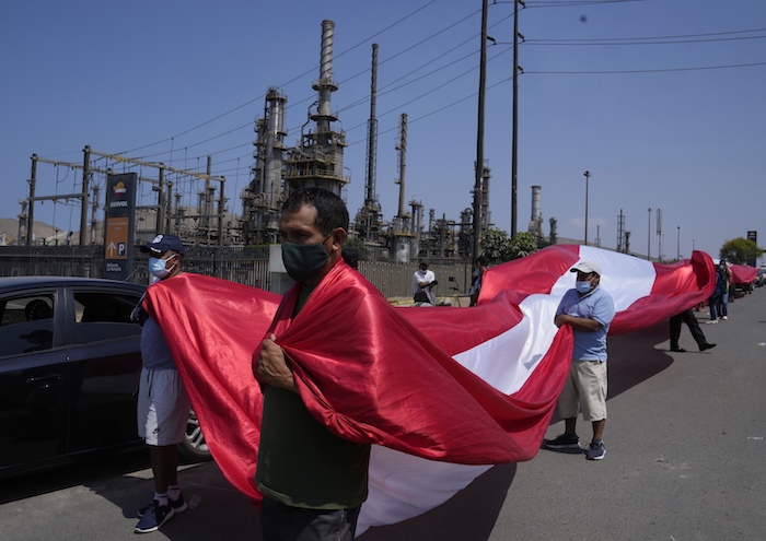 Pescadores artesanales protestan afuera de la planta de Repsol contra un derrame de petróleo en la playa Cavero en Ventanilla, Callao, Perú, el martes 18 de enero de 2022, luego de que las altas olas atribuidas a la erupción de un volcán submarino en Tonga causaran el derrame.