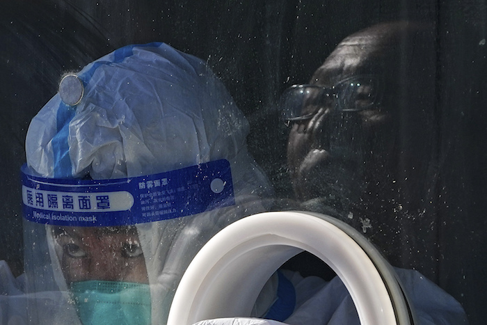 Un trabajador médico con equipo de protección recoge una muestra de un residente en un centro de pruebas de coronavirus el martes 25 de enero de 2022, en el distrito de Xichen en Beijing.