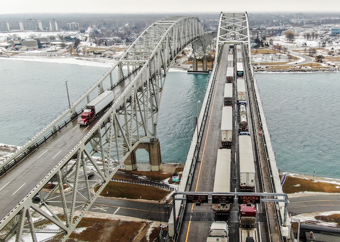 Imagen del pasado 11 de febrero de 2022 de una foto aérea hecha con un dron que muestra camiones (d) que entran en Canadá respaldados en el Puente de Agua Azul sobre el río St. Clair que une los Estados Unidos y Canadá.