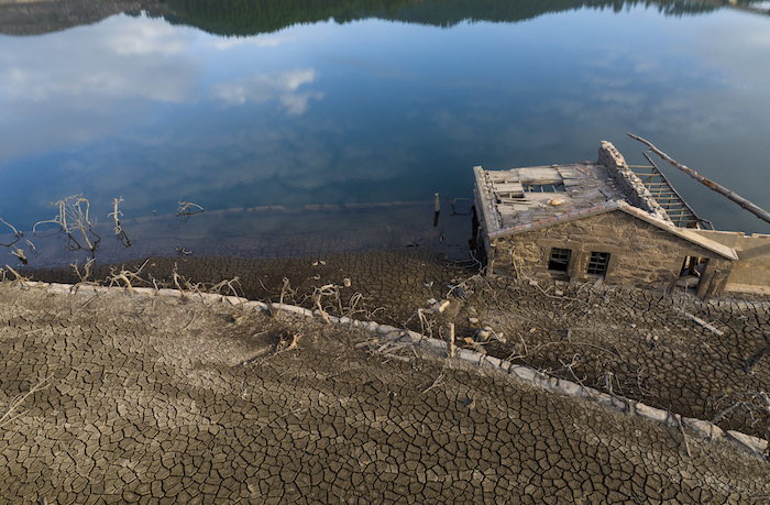 Una casa vieja, sumergida hace tres décadas cuando una presa hidroeléctrica inundó el valle, emerge debido a la sequía en el embalse de Lindoso, en el noroeste de España, el sábado 12 de febrero de 2022.