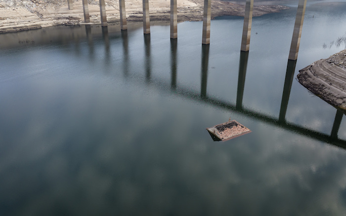 El tejado de una vieja casa sumergida hace tres décadas cuando una presa hidroeléctrica inundó el valle, emerge debido a la sequía en el embalse de Lindoso, en el noroeste de España, el sábado 12 de febrero de 2022.