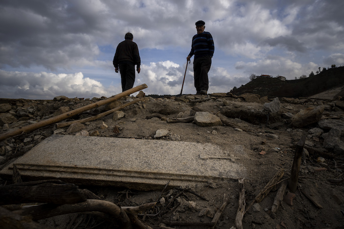 Julio Penín, de 78 años, mira a una tumba durante una visita al antiguo pueblo de Aceredo, accesible debido a la sequía en el embalse de Lindoso, en el noroeste de España, el viernes 11 de febrero de 2022.