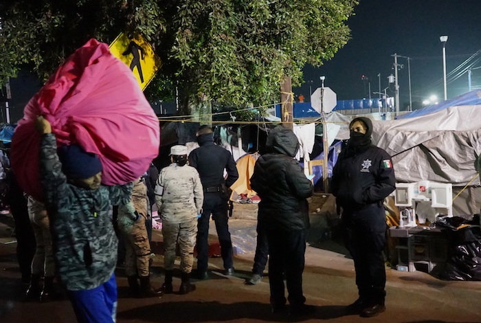 Migrantes retiran sus pertenencias del albergue "El Chaparral" hoy, en Tijuana (México).